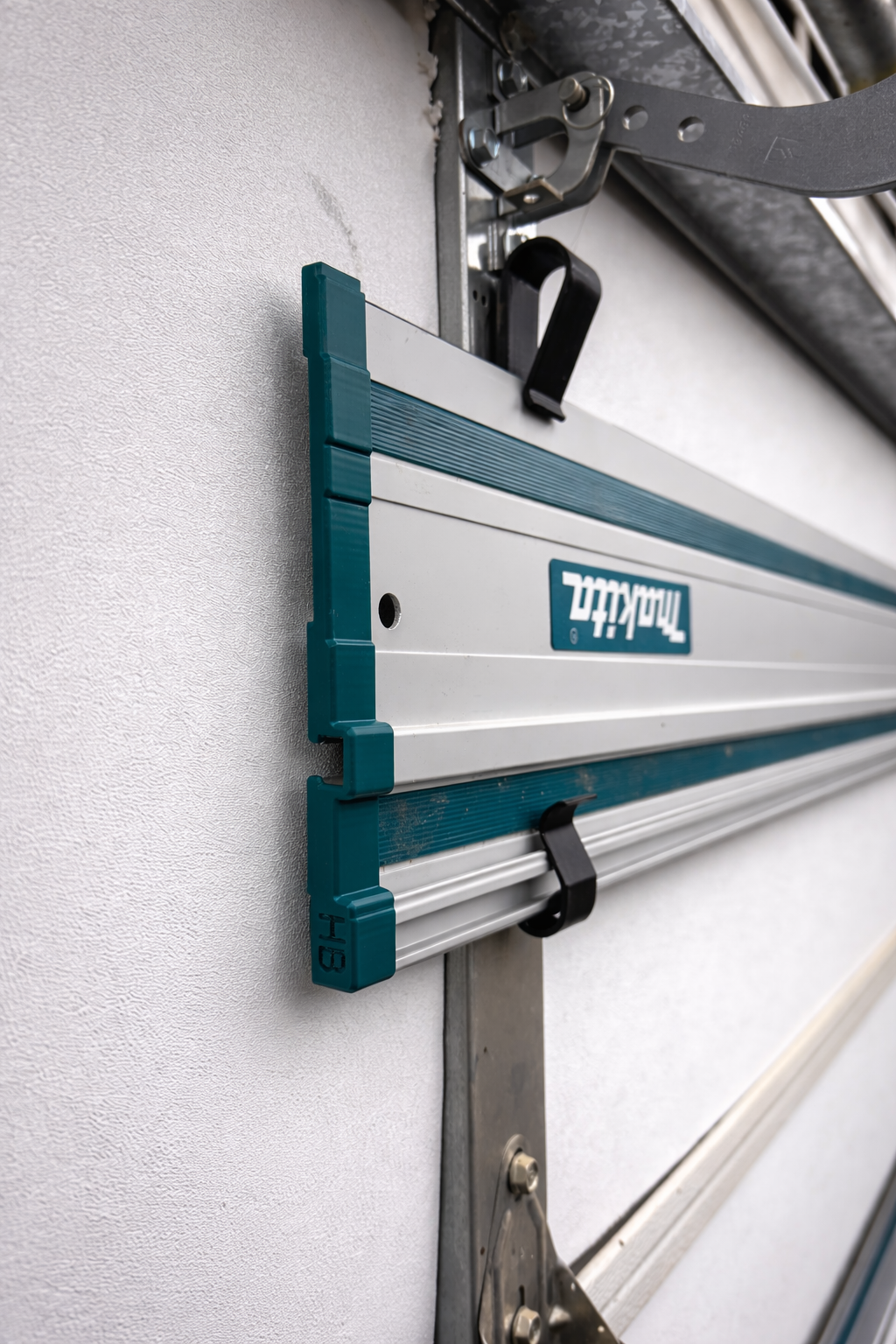 Track saw guide rail stored on a sectional garage door with Huntington Builds accessories